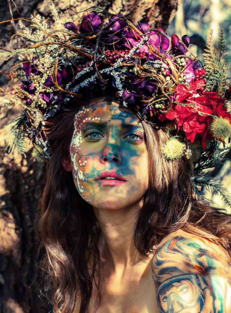 A girl adorned with face paint and headress, to represent the personification of Mother Earth